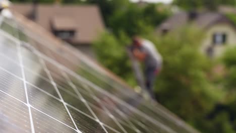 Solar-panel-installation,-blurred-technician-in-background,-cells-closeup