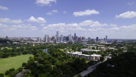 Aerial-view-over-the-Zilker-park,-towards-the-Austin-skyline-in-sunny-Texas,-USA