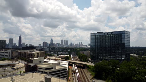 Arial-footage-of-a-train-going-by-in-the-city-of-Atlanta,-ga-during-a-warm-summer-afternoon