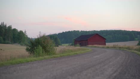Gravel-road-leading-to-an-old-barn.-Countryside