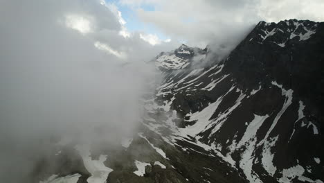 Schroffe-Schneebedeckte-Dolomiten-Mit-Wolkenfetzen,-Höhendrohnenflug,-Italien