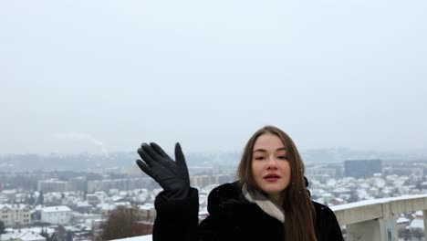 Attractive-white-female-model-waving-to-the-sky-outside-in-the-winter