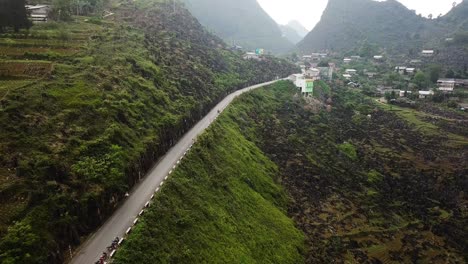 Aerial-view-following-the-Ma-Pi-Leng-Pass-uphill-towards-a-rural-town