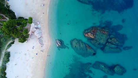 Playa-Coníferas-Rocas-En-Agua-Azul-Turquesa-Espectacular-Vista-Aérea-De-Pájaro-Vertical-9:16-Imágenes-De-Drones-En-La-Noche-En-España-Aro-Playa-Verano-2022