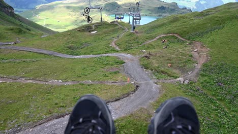 A-person-descends-the-mountain-comfortably-seated-on-his-chairlift,-descends-into-the-plain,-Swiss-Alps,-Obwalden,-Engelberg