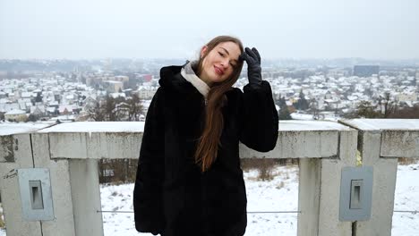 Zoom-in-to-an-attractive-young-female-model-posing-in-front-of-a-city-winter-day
