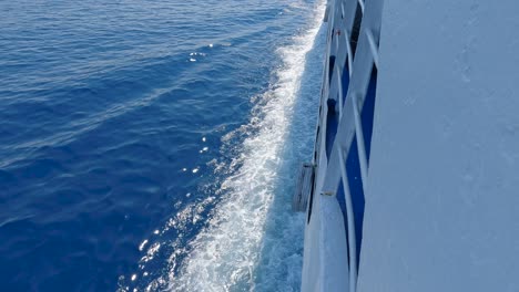 Topdown-view-onboard-Ferry-boat-sailing-at-open-sea-waters,-sea-foam-splashing-and-breaking