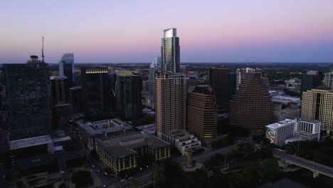 Purple-dusk-behind-skyscrapers-in-downtown-Austin,-in-Texas,-USA---Aerial-view