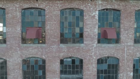 Panning-by-old-windows-of-an-abandoned-cotton-mill-during-sunrise-as-sunlight-fills-the-empty-room-in-McKinney-Texas