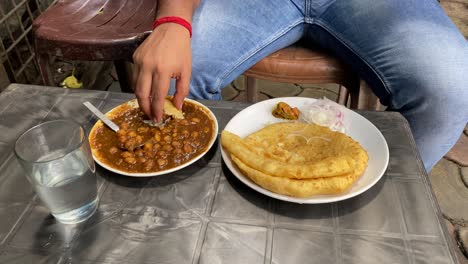 Man-eating-Puri-with-Chole-after-breaking-it