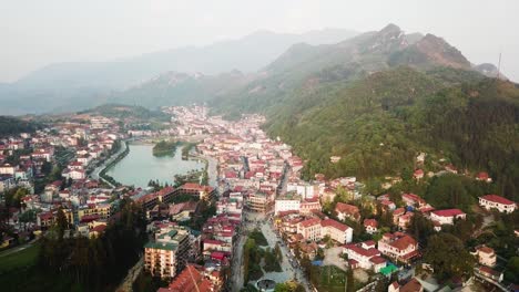 An-aerial-shot-flying-over-the-town-of-Sapa,-Vietnam,-toward-the-mountains