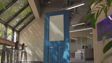 Filmaufnahme-Einer-Blauen-Tür-In-Einem-Innenarchitekturraum-Mit-Pflanzen-Und-Glasfenstern