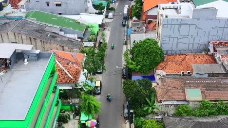 Aerial-top-down-of-delivery-drivers-on-motorbikes-driving-in-local-street-of-Jakarta