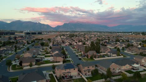 Typical-suburban-neighborhood-at-sunset-beneath-the-Wasatch-Front-Mountains-in-Lehi,-Utah---aerial-flyover