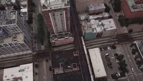 Aerial-footage-of-moving-train-in-Chicago,-Illinois-through-buildings