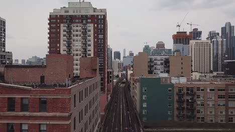 Aerial-footage-of-Chicago,-Illinois-following-elevated-train-tracks-through-buildings