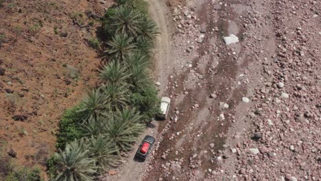 Aerial-top-down-view-of-three-expedition-vehicles-slowly-overcoming-difficult-terrain