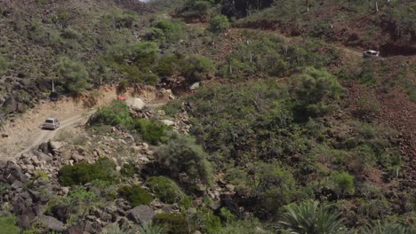 La-Cámara-Del-Dron-Se-Acerca-Lentamente-A-Los-Autos-De-La-Expedición-Mientras-Conducen-A-Través-De-Las-Colinas-En-Terrenos-Difíciles