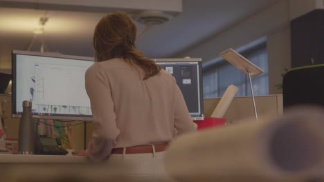 Back-shot-of-a-woman-working-in-front-of-a-computer-inside-an-architectural-office