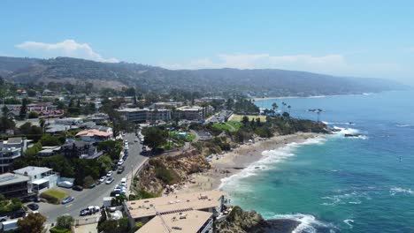 Aerial-View-of-Laguna-Beach-City-Waterfront,-Road-Traffic-and-Beachfront-Buildings,-Drone-Shot