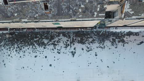 Aerial-drone-bird's-eye-view-over-damaged-roof-structure-of-a-burned-down-house
