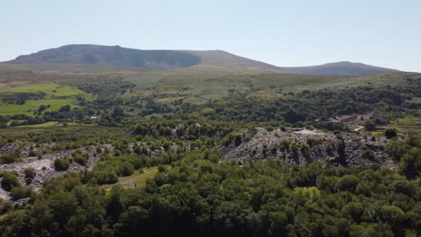 Dorothea-disused-overgrown-slate-mining-quarry-in-lush-dense-Snowdonia-mountain-woodland-aerial-view