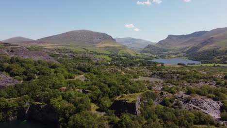 Dorothea-disused-overgrown-slate-mining-quarry-in-lush-dense-Snowdonia-mountain-woodland-wilderness-aerial-view