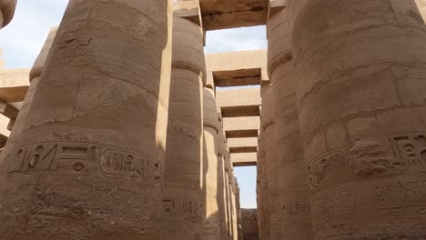 POV-Mirando-Hacia-Arriba-Y-Pasando-Por-Columnas-De-Piedra-Arenisca-En-El-Complejo-Del-Templo-De-Karnak-En-Egipto