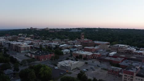 Aerial-wide-panning-shot-of-downtown-Lawrence,-Kansas-at-sunset
