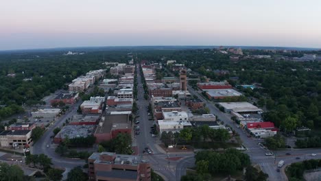 Reverse-pullback-aerial-panning-shot-of-downtown-Lawrence,-Kansas-at-sunset