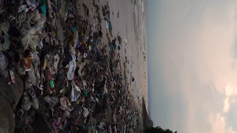 Tropical-Vietnamese-beach-covered-in-piles-of-washed-out-rubbish,-vertical-video