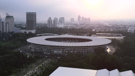 Amplia-Panorámica-De-Los-Edificios-Del-Horizonte-Del-Estadio-Gbk-Al-Atardecer-En-Yakarta,-Antena