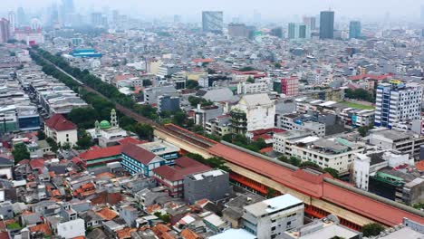 Aerial-skyline-of-Jakarta-residential-neighborhood-with-train-station-and-poor-air-quality