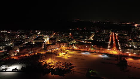 Aerial-view-around-the-illuminated-marina-and-cityscape-of-Drumso,-Finland---orbit,-drone-shot