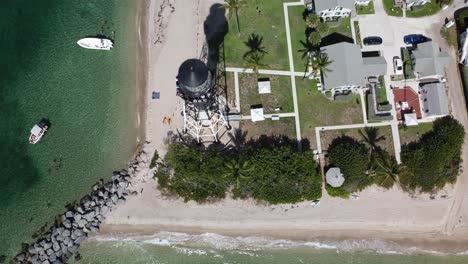 Hillsboro-Inlet-Lighthouse-From-an-Aerial-Drone-Looking-Down-and-Tilts-While-Pulling-Back-with-a-Scenic-View-of-the-Inlet-on-the-Coast-of-Florida
