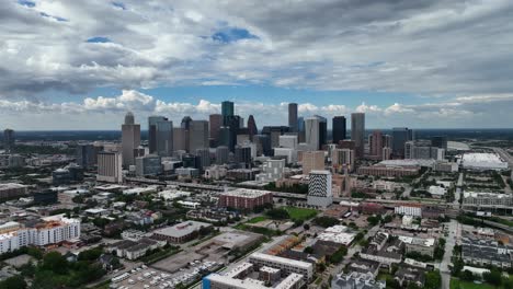 Aerial-view-leaving-the-city-center-of-Houston,-TX,-USA---pull-back,-drone-shot