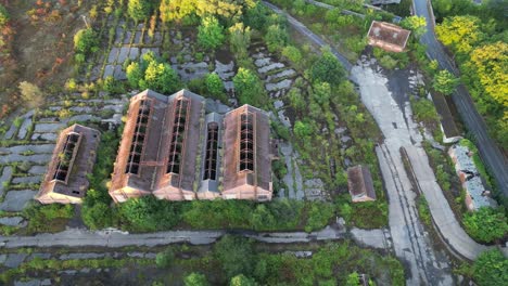 Drone-slowly-flying-around-an-abandoned-overgrown-coal-mining-complex