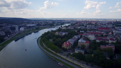 Aerial-view-across-charming-Cracow-Vistula-river-winding-around-gothic-picturesque-old-town-skyline