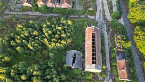 Drone-fly-over-of-a-disused-coal-mine,-with-dense-overgrown-vegetation