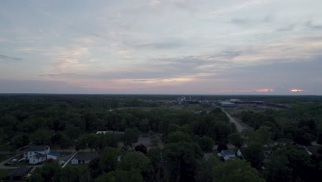 Aerial-drone-forward-moving-shot-over-an-old-lumber-mill-during-sunset-over-the-horizon