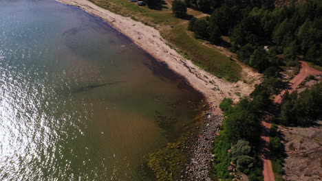 Vista-Aérea-Con-Vistas-A-La-Playa-Degersand,-Día-Soleado-De-Verano-En-Aland,-Finlandia---Inclinación,-Disparo-De-Drones