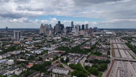Aerial-view-approaching-downtown-Houston,-cloudy,-summer-day-in-Texas,-USA