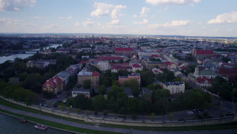 Vista-Aérea-Ascendente-De-La-Ciudad-De-Cracovia-Con-El-Río-Vístula-Y-El-Puente-Al-Atardecer,-Polonia