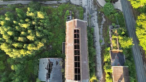 Birds-eye-view-directly-into-a-derelict,-overgrown,-coal-mining-building