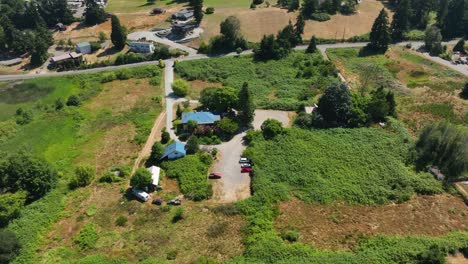 Aerial-view-of-a-house-on-an-overgrown-lot-of-shrubs-on-a-warm-summer-day