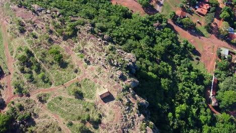 Aerial-drone-bird's-eye-view-of-huts-on-top-of-Cerro-Yaguaron,-which-is-mound-located-in-Paraguay,-South-America