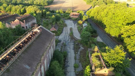 Drone,-close-to-the-ground,-slowly-flying-through-an-abandoned-coal-mining-complex