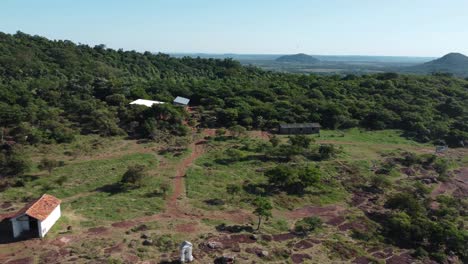 Aerial-drone-backward-moving-shot-of-houses-on-top-of-Cerro-Yaguaron,-which-is-mound-located-in-Paraguay,-South-America