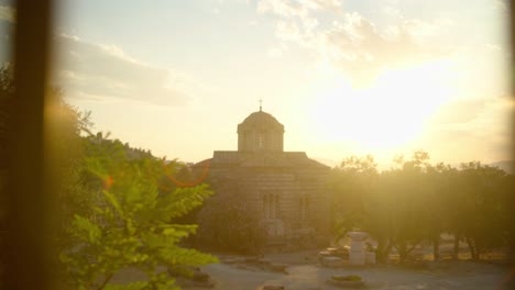 Ancient-greek-church-in-the-sunset,-slow-movement-with-sun-flare