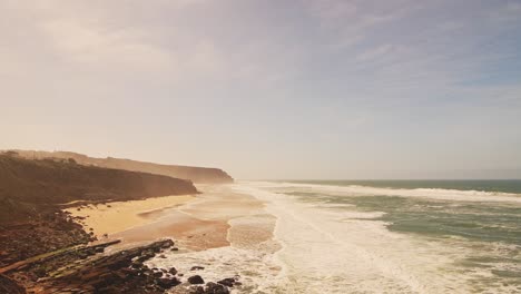 Luftdrohnenansicht-Des-Sandstrandes-Praia-Grande-Mit-Klippen,-Zeigt-Küstenlandschaft-Und-Küstenlinie-In-Sintra,-Lissabon,-Portugal,-An-Der-Atlantikküste,-Einem-Wunderschönen-Touristenziel,-Europa